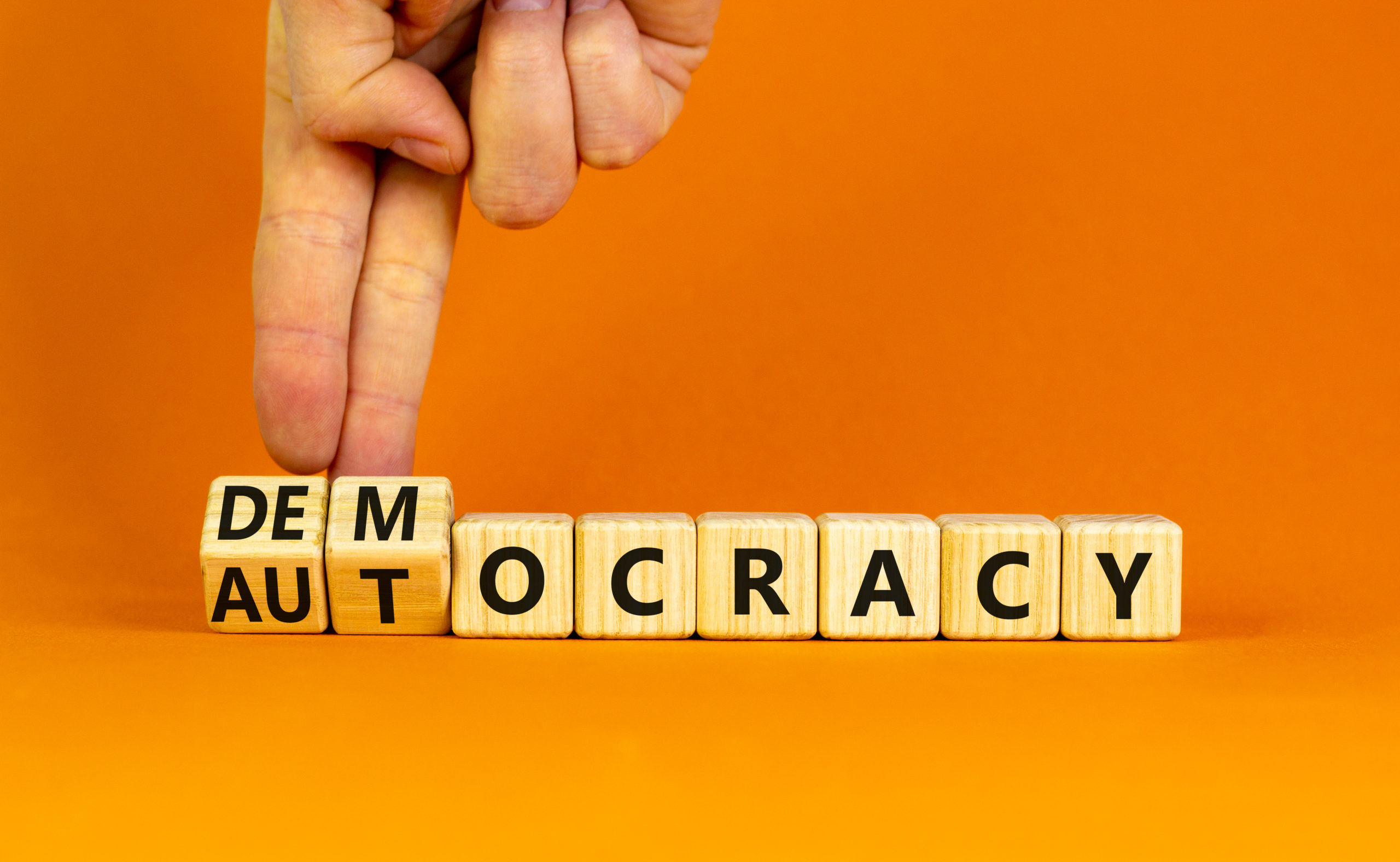 Democracy,Or,Autocracy,Symbol.,Businessman,Turns,Wooden,Cubes,And,Changes